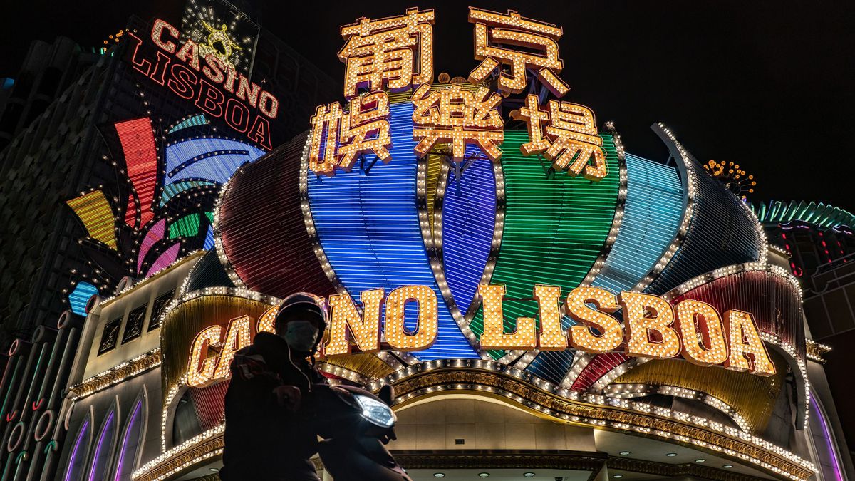 MACAU, CHINA - FEBRUARY 04: A motorcyclist stops for a traffic light in front of the Casino Lisboa on February 4, 2020 in Macau, China. Macau government announced to close casinos for two weeks after a hotel worker is infected. Macau has 10 confirmed cases of Novel coronavirus (2019-nCoV), with over 20,000 confirmed cases around the world, the virus has so far claimed over 400 lives.