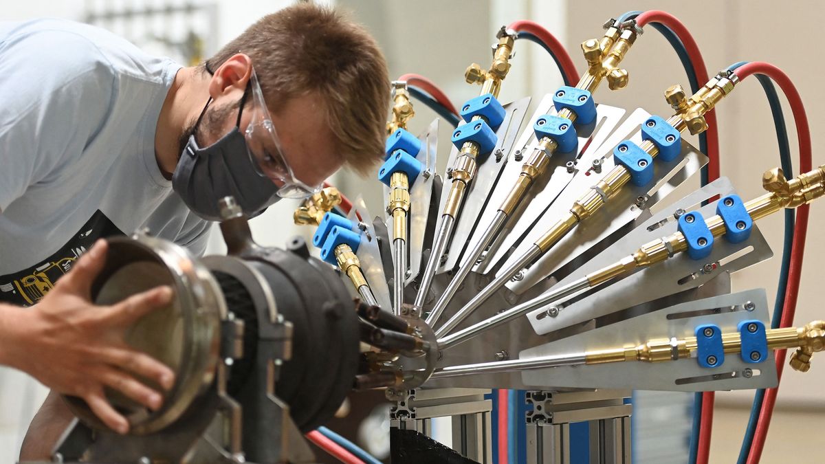 A mechanic adjusts a nozzle in a heat flux test stand at Rocket Factory Augsburg in Augsburg, southern Germany on June 16, 2021. - Rocket Factory Augsburg is developing a low cost space rocket designed to transport micro sattelites to their desitanted orbits. Car-manufacturing powerhouse Germany could soon be set for take-off in the space sector as it looks to ride a boom in mini-launchers for small satellites and compete with major US firms such as SpaceX. (Photo by LENNART PREISS / AFP) / TO GO WITH AFP STORY by Jean-Philippe LACOUR