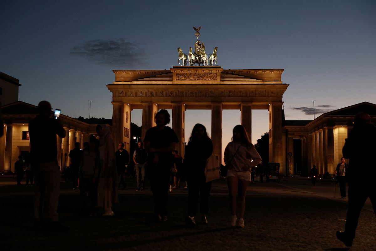 BERLIN, GERMANY - SEPTEMBER 01: People walk among the iluminated Brandenburg Gate, one of Berlin's premiere landmarks, on the first day a new law to save energy nationwide has gone into effect on September 1, 2022 in Berlin, Germany. The new law encompasses a wide variety of temporary measures, including banning the illumination of landmarks, regulating minimum temperature controls in both public and private venues, restricting the illumination of advertising billboards, as well as other measures, in order to save heat and electricity. The measures are a response to diminished natural gas and other energy supplies from Russia as well as skyrocketing inflation, both brought on by Russia's ongoing war in Ukraine. 