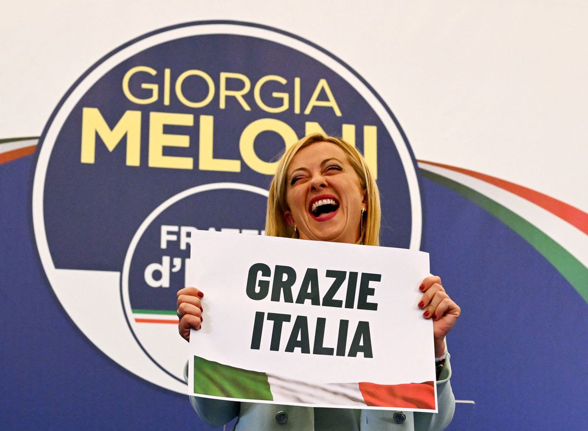 Leader of Italian far-right party "Fratelli d'Italia" (Brothers of Italy), Giorgia Meloni reacts as she holds a placard reading "Thank You Italy" after she delivered an address at her party's campaign headquarters overnight on September 26, 2022 in Rome, after the country voted in a legislative election. - Far-right leader Giorgia Meloni won big in Italian elections on September 25, the first projections suggested, putting her eurosceptic populists on course to take power at the heart of Europe. 