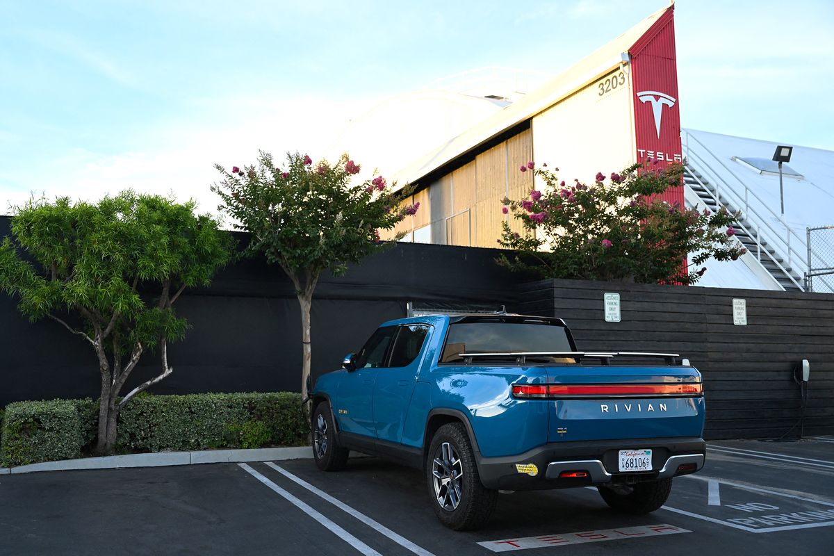 Elon Musk sells nearly $7 billion worth of Tesla shares: document, A Rivian R1T electric pickup truck sits parked outside a Tesla Inc. location in Hawthorne, California, on August 9, 2022. - Elon Musk has sold nearly $7 billion worth of Tesla shares, according to legal filings published August 9, 2022, amid a high-stakes legal battle with Twitter over a $44 billion buyout deal. (Photo by Patrick T. FALLON / AFP) Tesla-business-US-TRANSPORT-AUTOMOBILE-TESLA-Musk-shares-compute