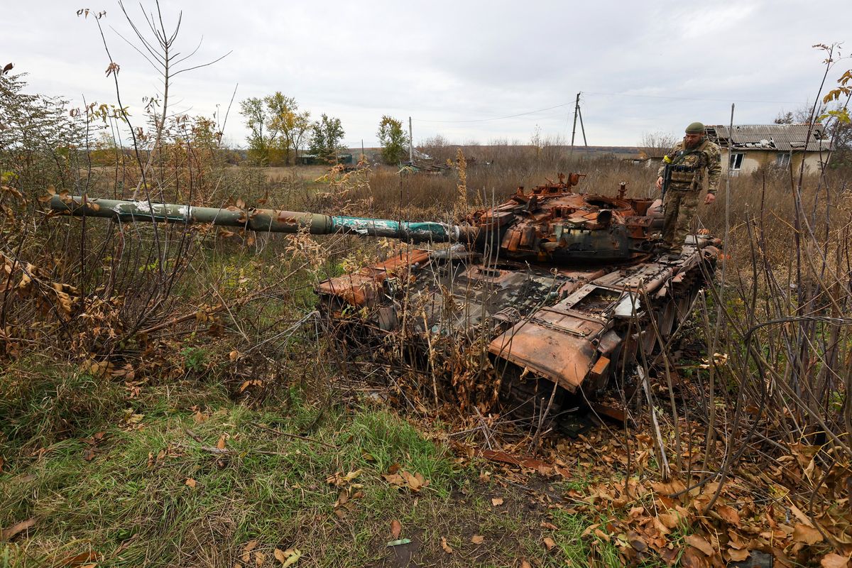 Consequences of Russian shelling in north of Kharkiv Region, TSUPIVKA, UKRAINE - OCTOBER 25, 2022 - A Ukrainian soldier stands on top of a destroyed Russian tank in Tsupivka village in the north of Kharkiv Region, northeastern Ukraine. NO USE RUSSIA. NO USE BELARUS. (Photo by Vyacheslav Madiyevskyy / NurPhoto / NurPhoto via AFP)