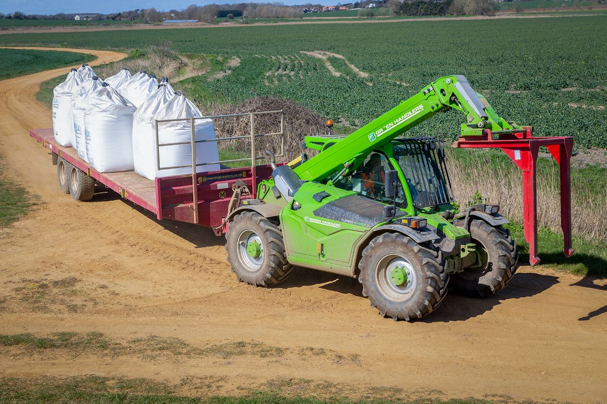 Telehandler vehicle with trailer carrying bags of nitrate fertilizer, Alderton, Suffolk, England, UK