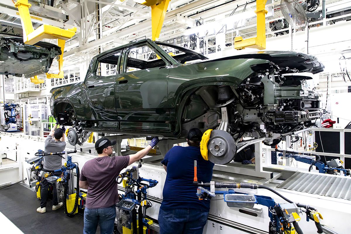 BIZ-AUTO-RIVIAN-PRODUCTION-TB, Workers lower an R1T truck body onto a chassis in the assembly line at the Rivian electric vehicle plant in Normal, Illinois, on April 11, 2022. (Brian Cassella/Chicago Tribune/Tribune News Service via Getty Images)