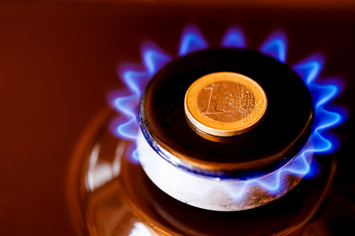 Gas stove burner with one euro coin laid on top,Burning natural gas, gas stove burner with one euro coin laid on top, burning natural gas with blue flame, gas price in European Union concept