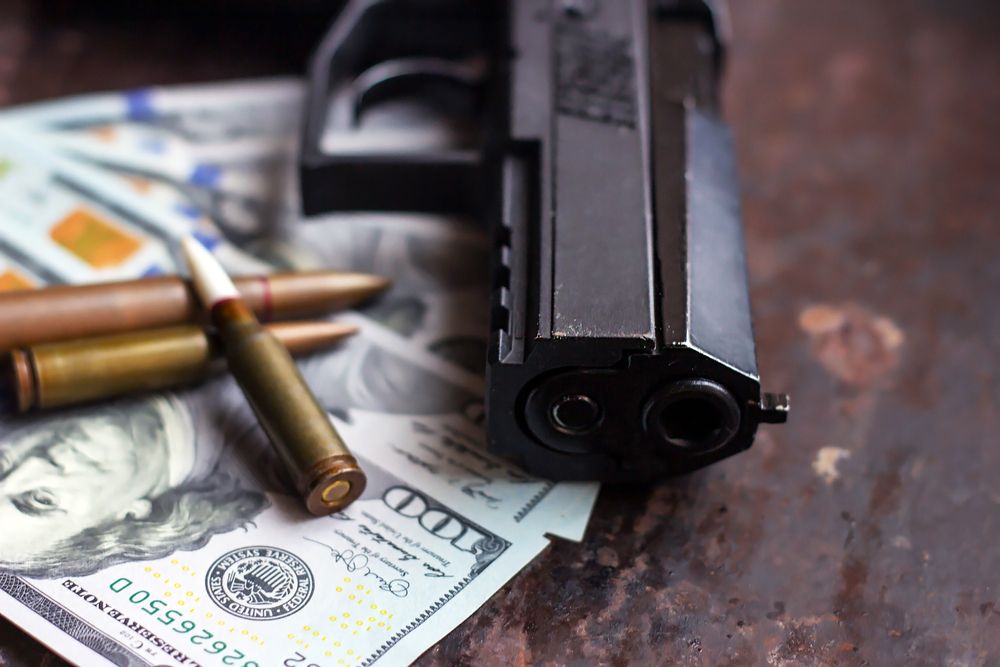 Black,Gun,And,Bullets,On,American,Dollars,Background.,Military,Industry,
