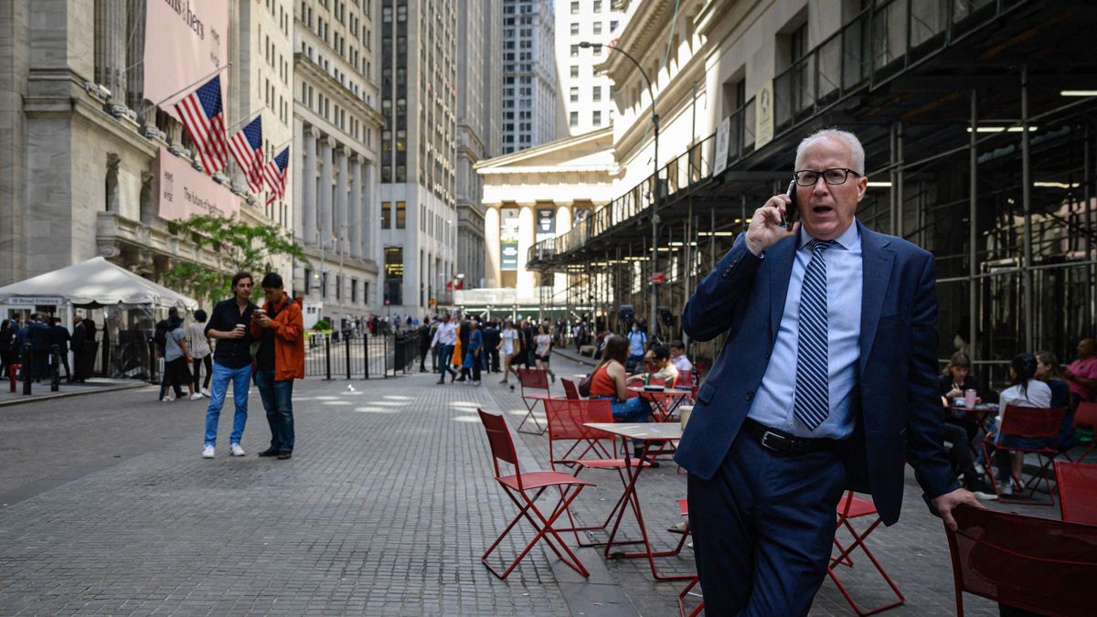 A man speaks on a phone outside the Stock Exchange in New York on June 14, 2022. - Stock markets diverged on Tuesday as investors fret over the possibility that the US Federal Reserve will move aggressively to combat inflation. (Photo by Ed JONES / AFP) amerika, tőzsde, utcakép, üzletember, öltöny