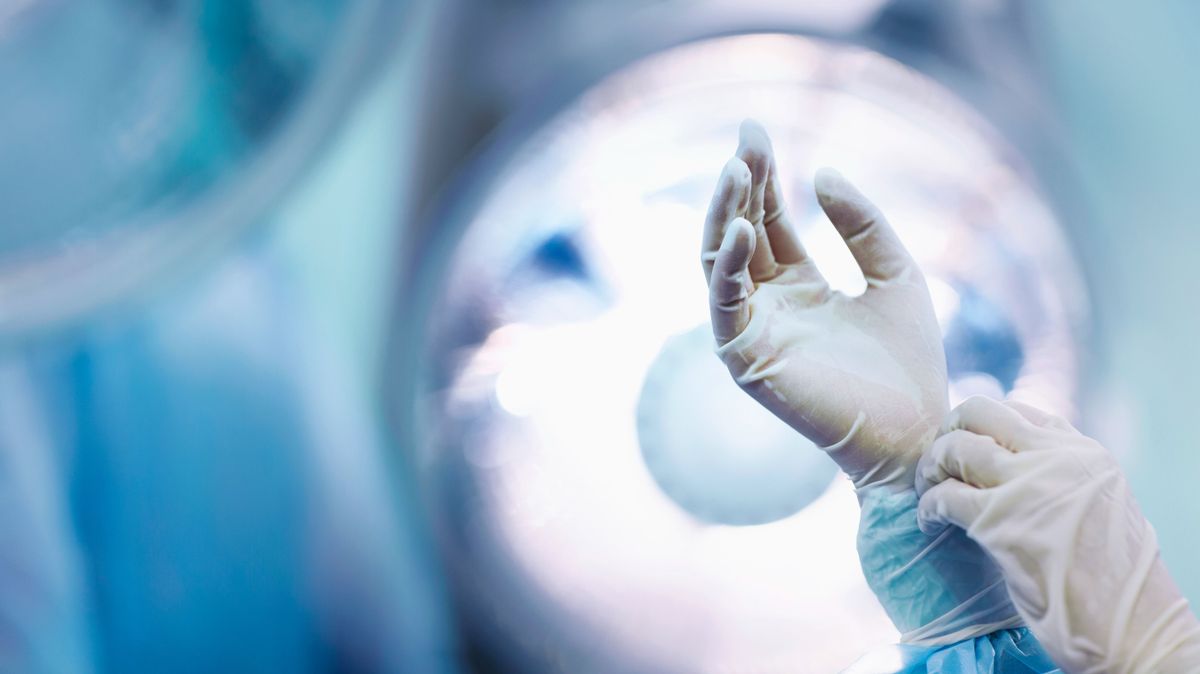 Surgeon adjusting glove in operating room, kórház ,egészségügy, hospital