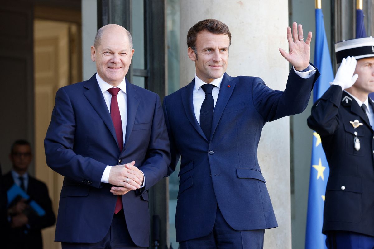 France's President Emmanuel Macron (R) waves as he welcomes German Chancellor Olaf Scholz upon his arrival for a lunch at the presidential Elysee Palace in Paris on October 26, 2022. - The two leaders aim to "strengthen Franco-German cooperation" and respond to common challenges in a "united and supportive way", to revive the Franco-German tandem, plagued by a series of disputes, from energy to defense, against the backdrop of the war in Ukraine. 