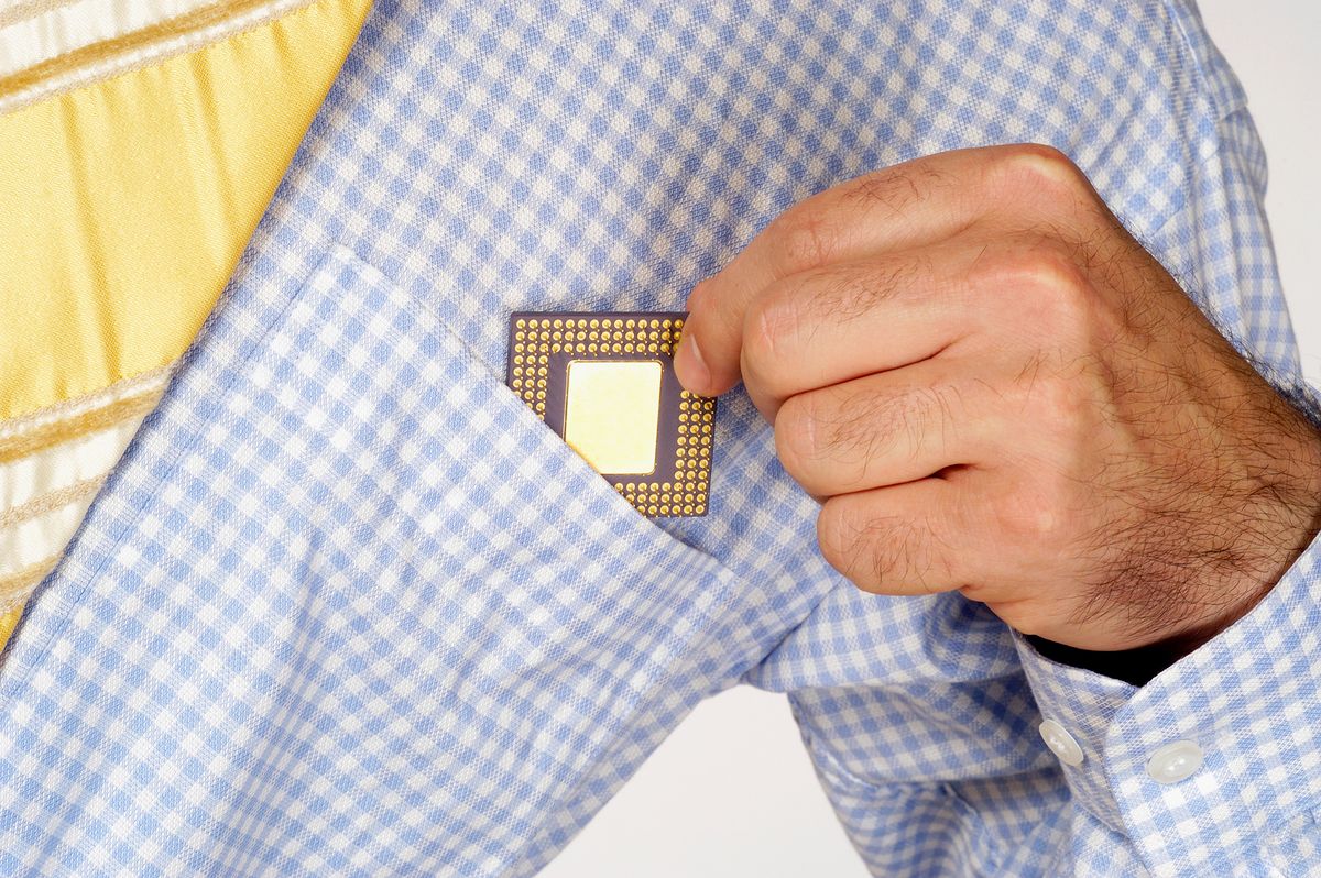 Mid section view of a businessman putting a computer chip into his shirt pocket