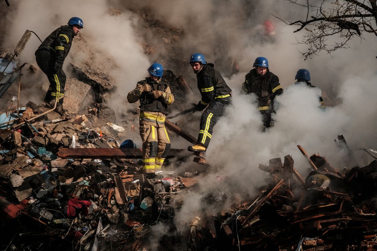 Ukrainian firefighters works on a destroyed building after a drone attack in Kyiv on October 17, 2022, amid the Russian invasion of Ukraine. - Ukraine officials said on October 17, 2022 that the capital Kyiv had been struck four times in an early morning Russian attack with Iranian drones that damaged a residential building and targeted the central train station. 