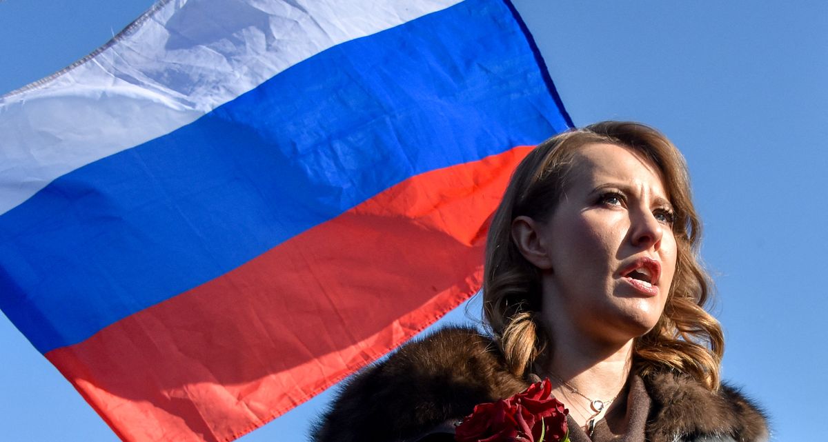 Russian presidential candidate Ksenia Sobchak speaks next to a Russian flag in central Moscow on February 27, 2018 at the site where late opposition leader Boris Nemtsov was fatally shot on a bridge near the Kremlin. - A march in memory of Kremlin critic Boris Nemtsov gathered several thousand Muscovites on February 25, in a rare sanctioned opposition gathering ahead of next month's presidential vote. (Photo by Vasily MAXIMOV / AFP)