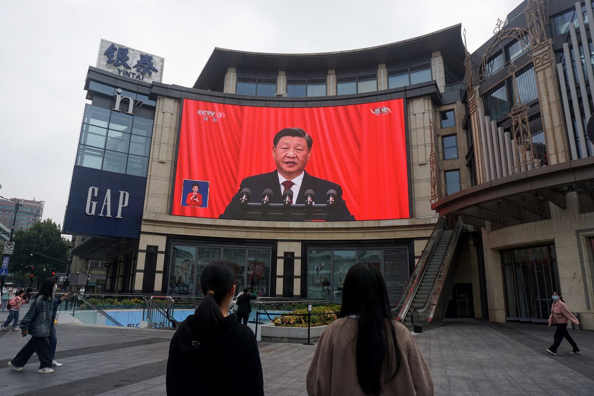 People watch an outdoor screen showing the live speech of Chinese President Xi Jinping during the opening session of the 20th Chinese Communist Party Congress in Hangzhou, in China’s eastern Zhejiang province on October 16, 2022. (Photo by AFP) / China OUT