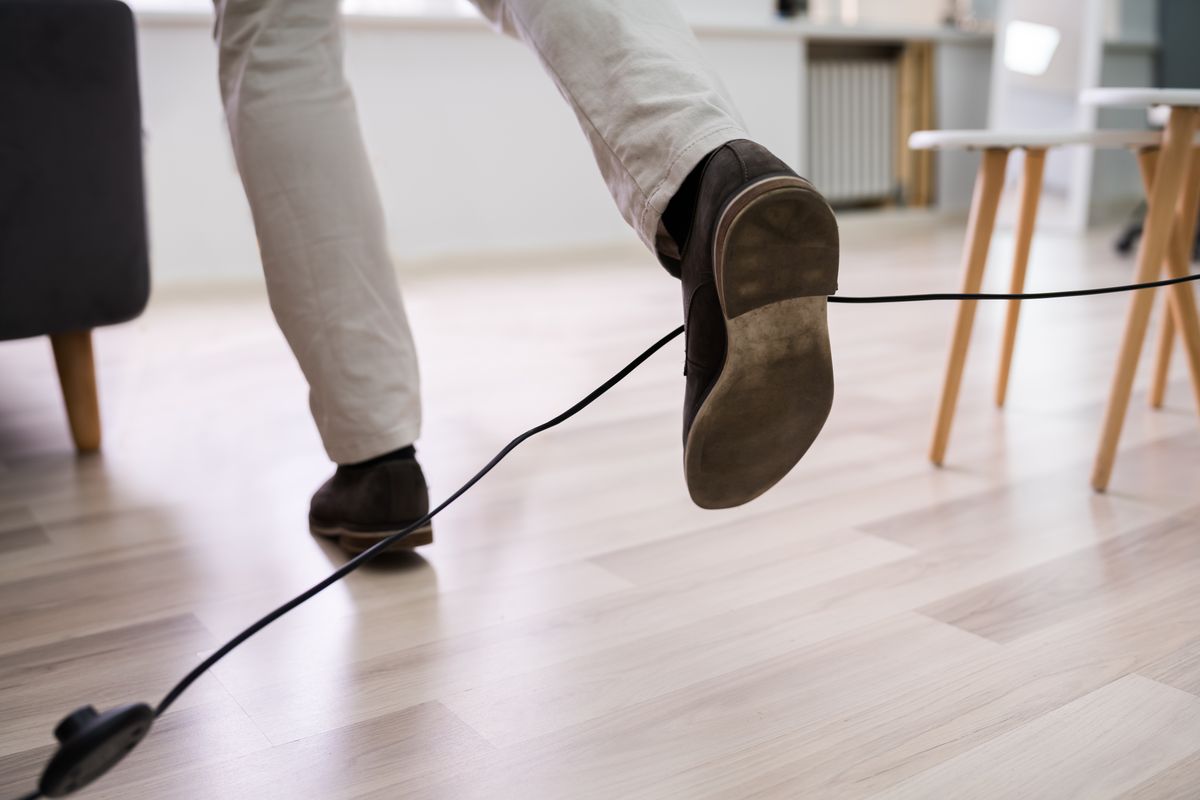 Close-up,Of,A,Man,Legs,Stumbling,With,An,Electrical,Cord