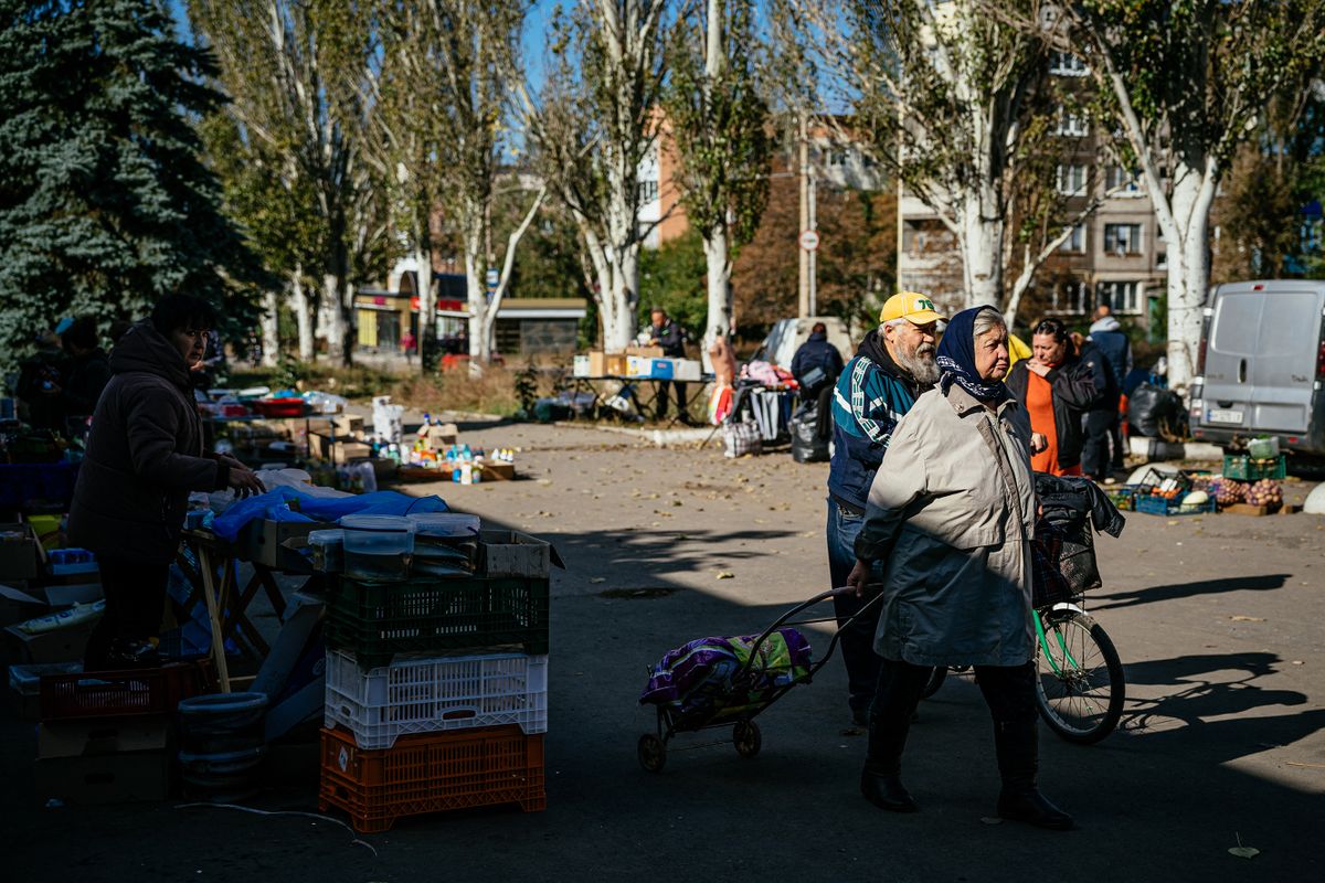 Local residents shop at an open air market in the outskirts of the town of Bakhmut on October 15, 2022, amid the Russian invasion of Ukraine. 