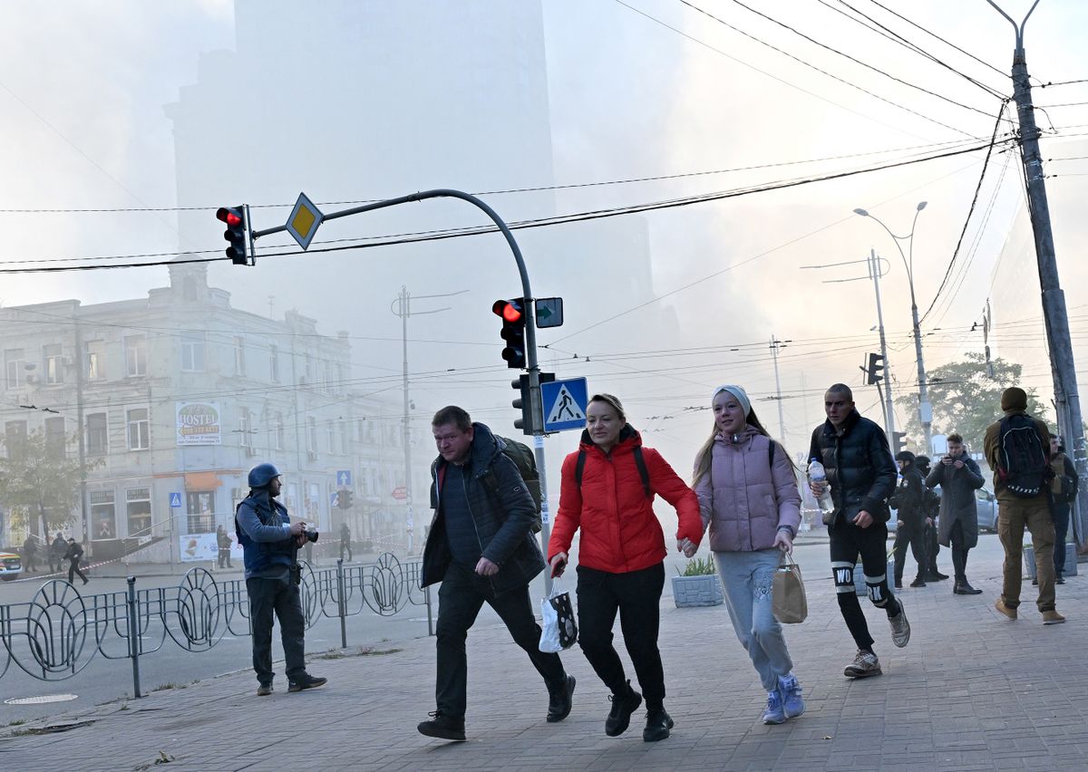 Local residents run away after a drone attack in Kyiv on October 17, 2022, amid the Russian invasion of Ukraine. - Ukraine officials said on October 17, 2022 that the capital Kyiv had been struck four times in an early morning Russian attack with Iranian drones that damaged a residential building and targeted the central train station. 