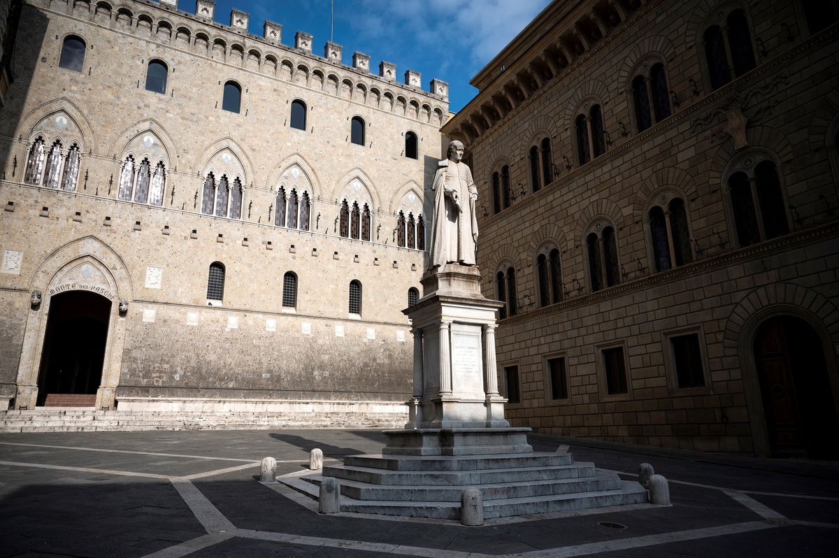 A picture taken on March 4, 2022 shows the statue of Italian 18th Century archdeacon, economist, and politician, Sallustio Bandini by the 14th Century Gothic style urban palace Palazzo Salimbeni, headquarters of the Italian bank Monte dei Paschi di Siena, one of the world's oldest bank, in Siena, Tuscany. (Photo by MARCO BERTORELLO / AFP)