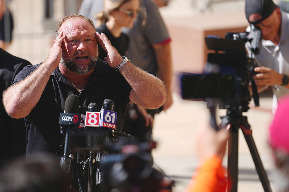 Alex Jones Speaks To The Media Outside The Sandy Hook Trial In Waterbury, Connecticut, WATERBURY, CONNECTICUT - SEPTEMBER 21: InfoWars founder Alex Jones speaks to the media outside Waterbury Superior Court during his trial on September 21, 2022 in Waterbury, Connecticut. Jones is being sued by several victims' families for causing emotional and psychological harm after they lost their children in the Sandy Hook massacre. A Texas jury last month ordered Jones to pay $49.3 million to the parents of 6-year-old Jesse Lewis, one of 26 students and teachers killed in the shooting in Newtown, Connecticut. (Photo by Joe Buglewicz/Getty Images)