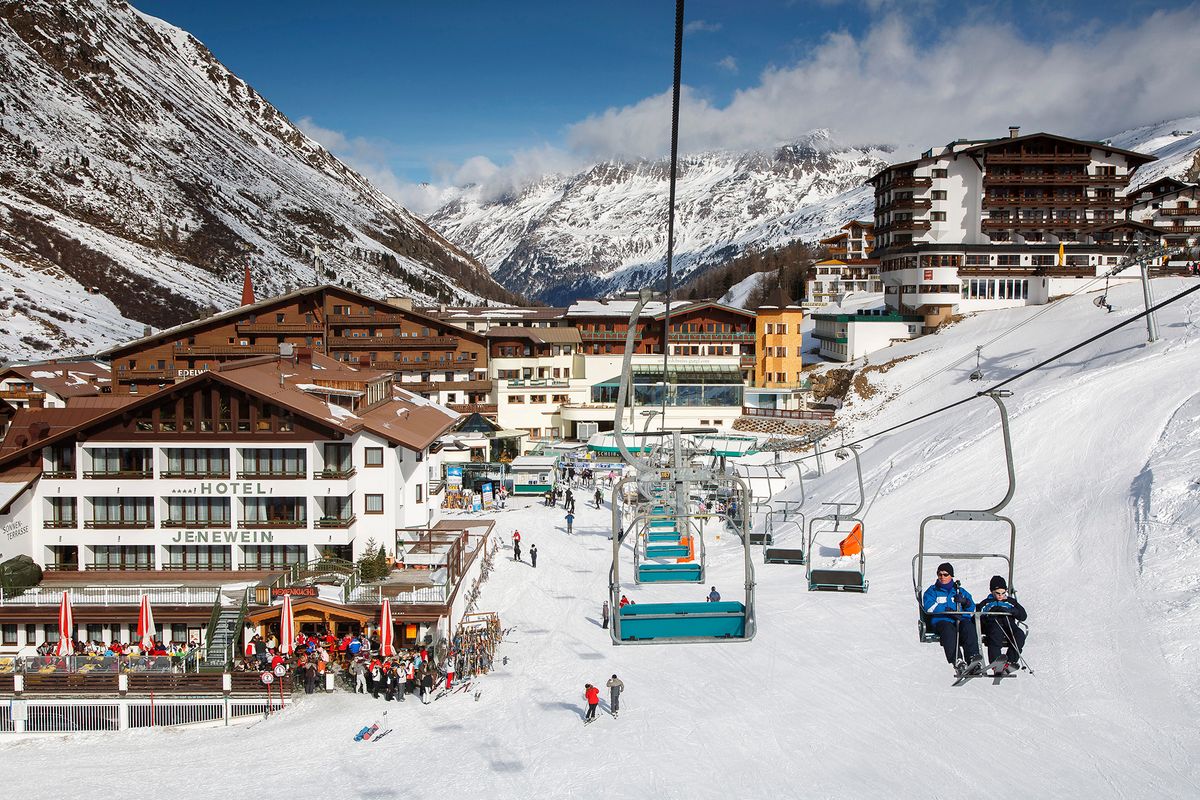 The alpine skiing village of Obergurgl with skiers relaxing while others head off on chairlifts to runs in the Otztal Alps, Tyrol, Austria, Europe