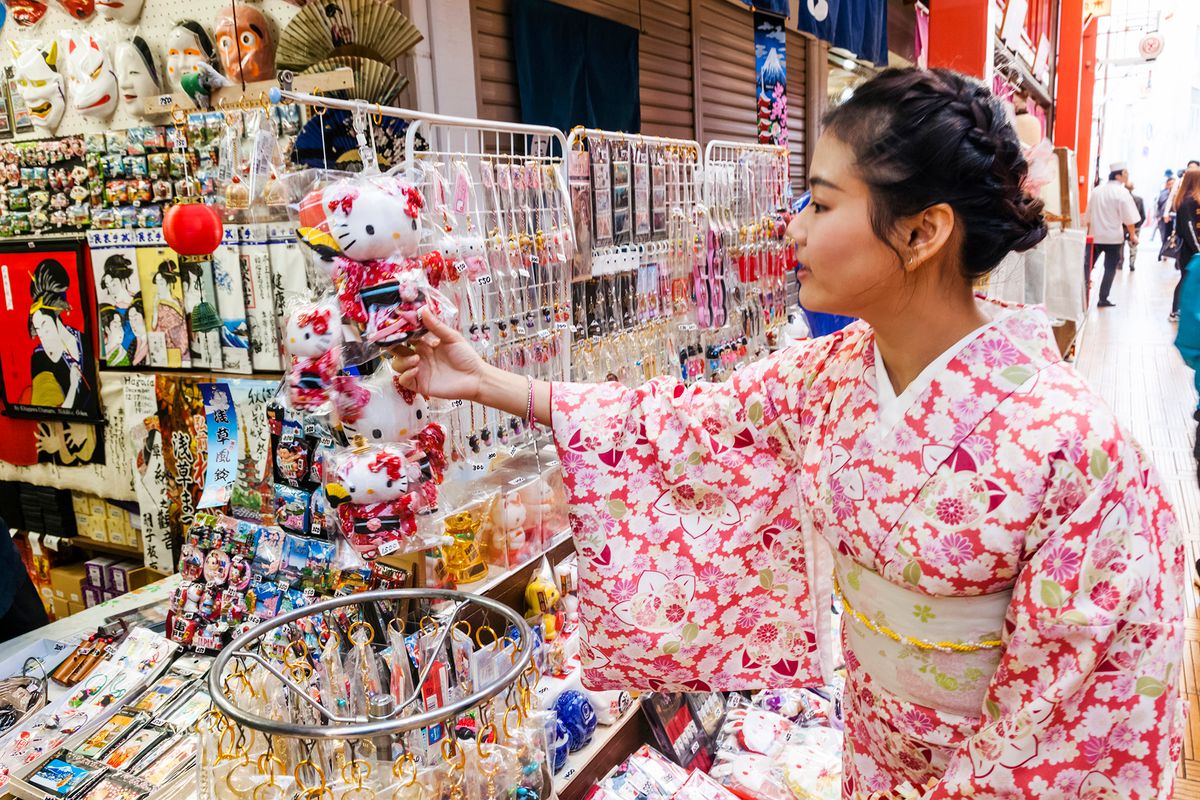 Japan, Hoshu, Tokyo, Asakusa, Nakamise Shopping Street, Girl in Kimono Buying Souvenirs