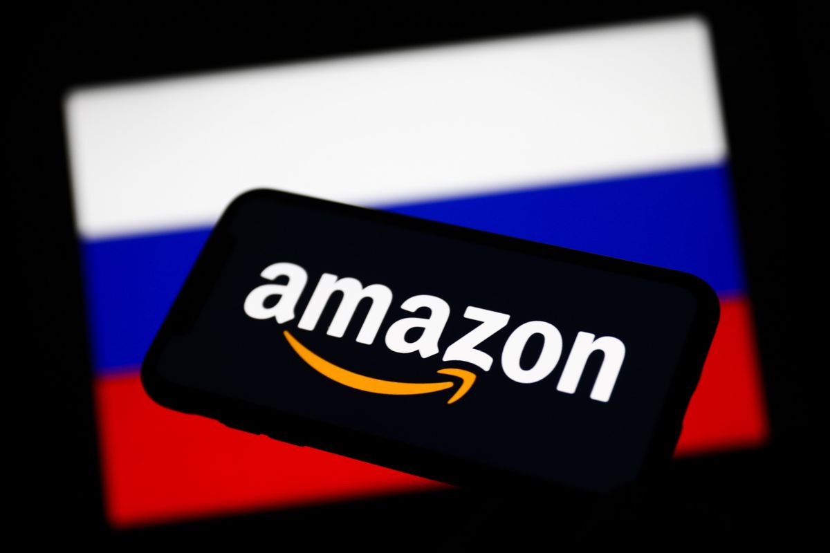 Amazon logo displayed on a phone screen and Russian flag displayed on a screen in the background are seen in this illustration photo taken in Krakow, Poland on March 1, 2022. 