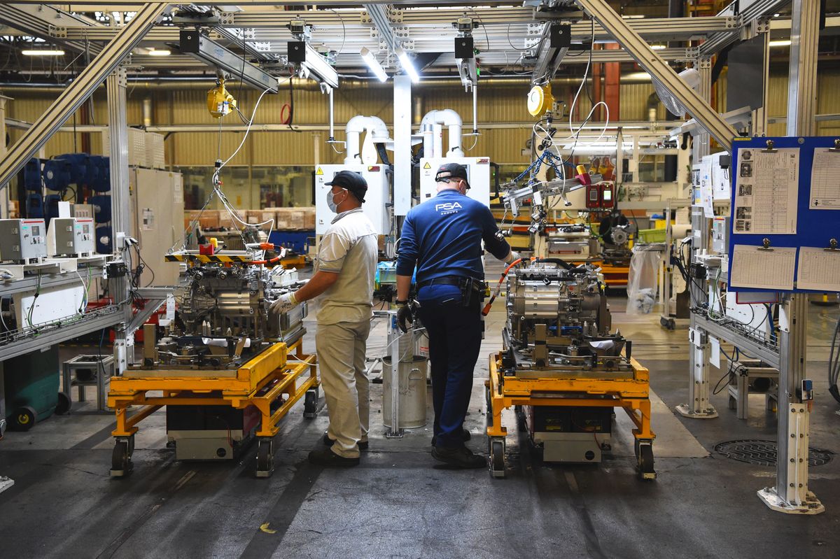 Employees work on an electric engine assembly line at automaker Stellantis plant in Tremery, eastern France, on January 27, 2022. - Stellantis, a company from the merger of Fiat Chrysler and PSA, creates the 4th largest automobile group in the world. (Photo by Eric PIERMONT / AFP) FRANCE-ECONOMY-INDUSTRY-TRANSPORT-STELLANTIS