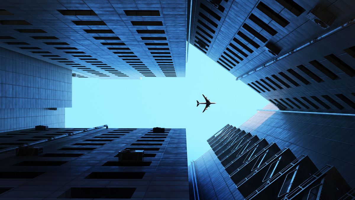 Arrow city, Digital generated image of buildings making arrow sign with airplane flying on blue sky. gazdaság, economy, irány, arrow, nyíl, 