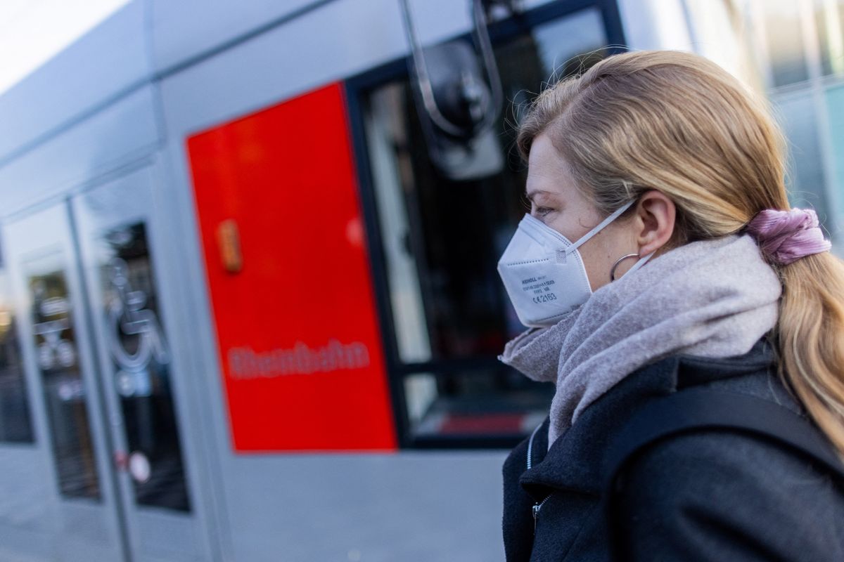 30 September 2022, North Rhine-Westphalia, Duesseldorf: A woman wearing an FFP2 mask waits for her streetcar at Graf-Adolf-Platz. The Corona rules in North Rhine-Westphalia will continue to apply unchanged until the end of October. 