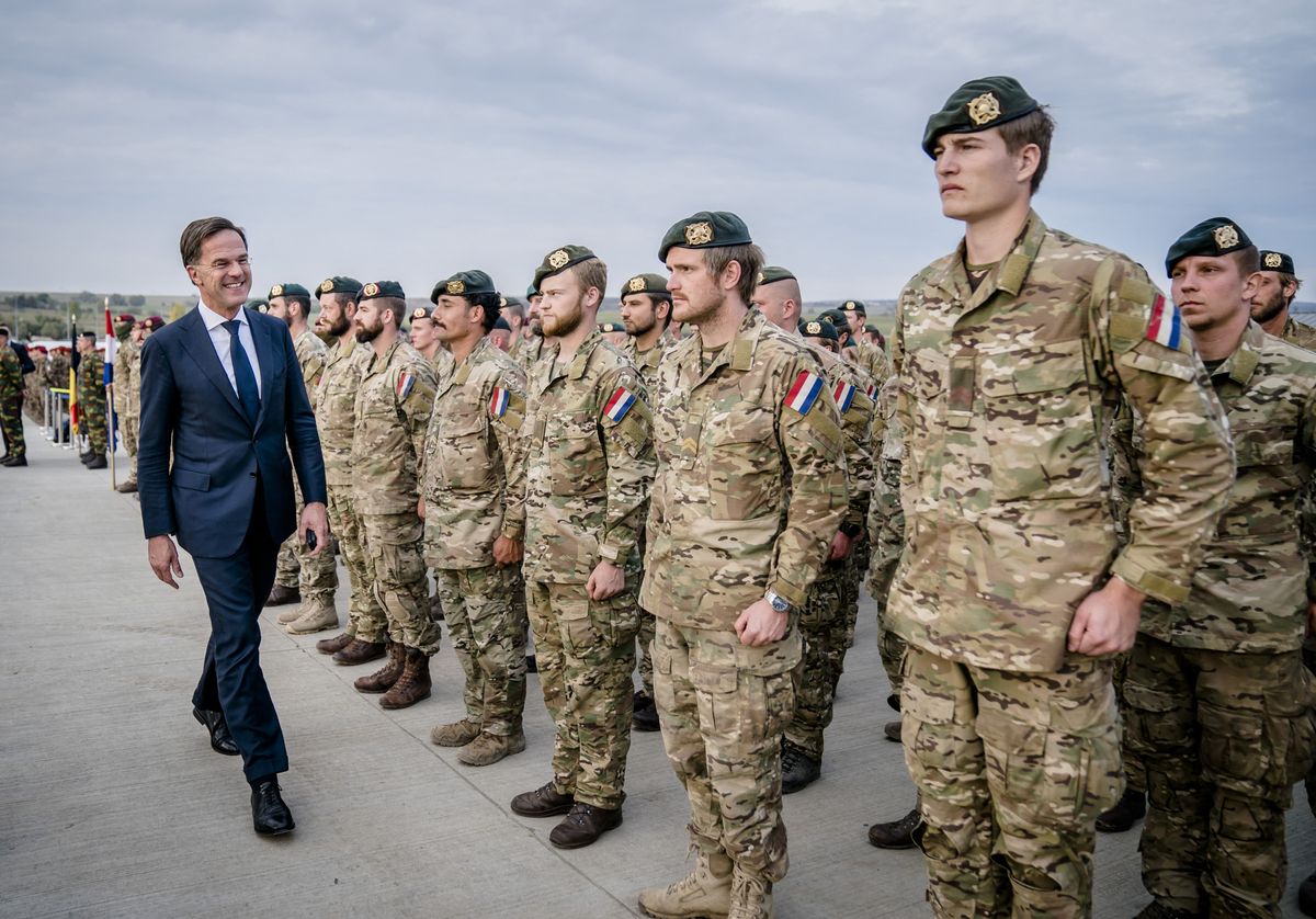 2022-10-12 16:36:24 CINCU - Prime Minister Mark Rutte, President Klaus Johannis and Prime Minister Nicolae Ciuca, pose with Dutch soldiers at a military base where Dutch troops are stationed, during a visit to Romania. The prime minister discusses, among other things, military cooperation between the Netherlands and Romania. ANP BART MAAT netherlands out - belgium out (Photo by BART MAAT / ANP MAG / ANP via AFP)