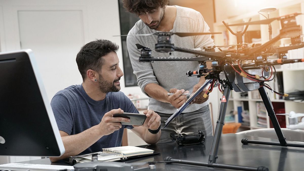 Engineer,And,Technician,Working,Together,On,Drone,In,Office