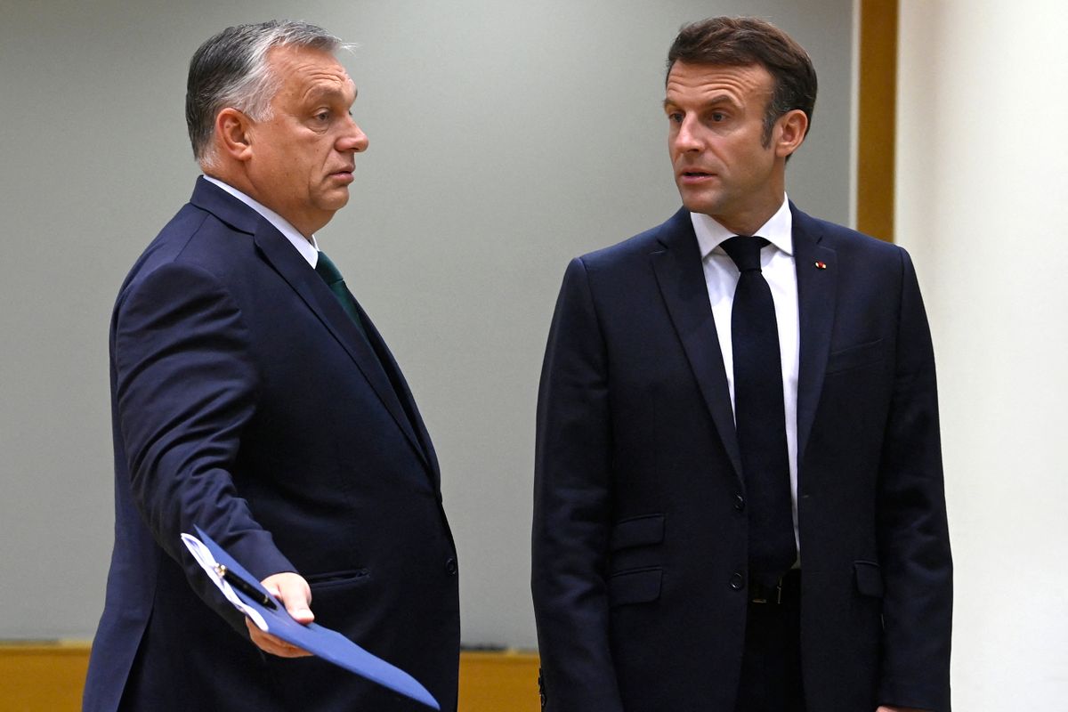 Hungary's Prime Minister Viktor Orban (L) speaks with France's President Emmanuel Macron (R) ahead of a meeting on the second day of a EU leaders Summit at The European Council Building in Brussels on October 21, 2022. 