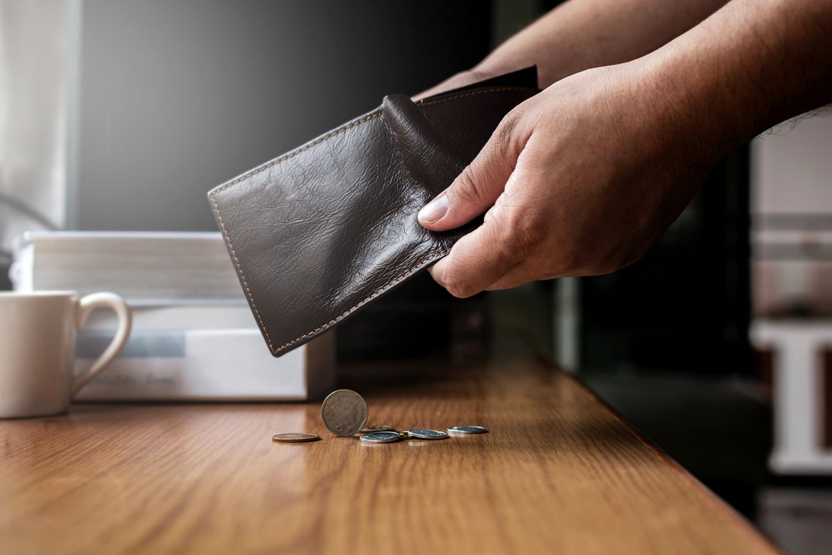 Checking,And,Pour,Money,In,Leather,Wallet,On,The,Working Checking and pour money in leather wallet on the working desk with soft light from outside 