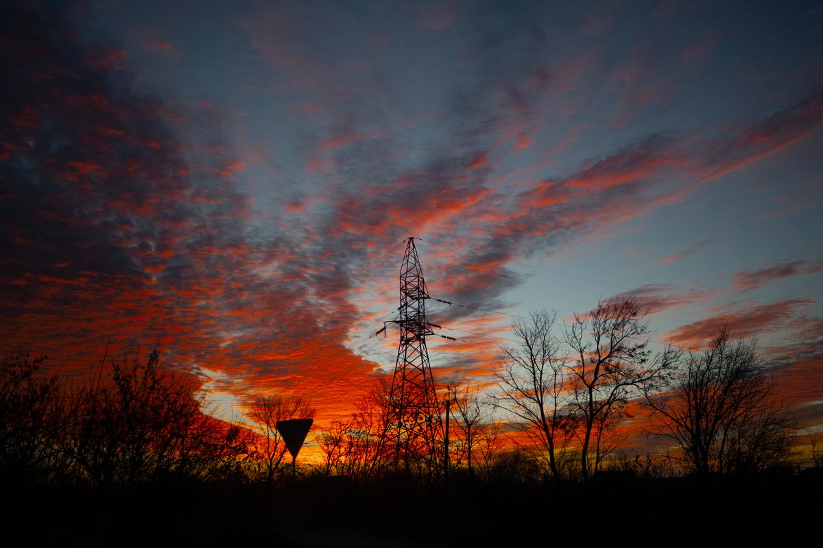 This photograph taken on November 14, 2022, shows a morning sky and an overhead power line  near the road between newly liberated Kherson and Mykolaiv in Ukraine. - The takeover by Ukrainian troops of the Kherson region is the latest in a string of setbacks for Russia, which invaded Ukraine on February 24 hoping for a lightning takeover and to topple the government in days. (Photo by BULENT KILIC / AFP)