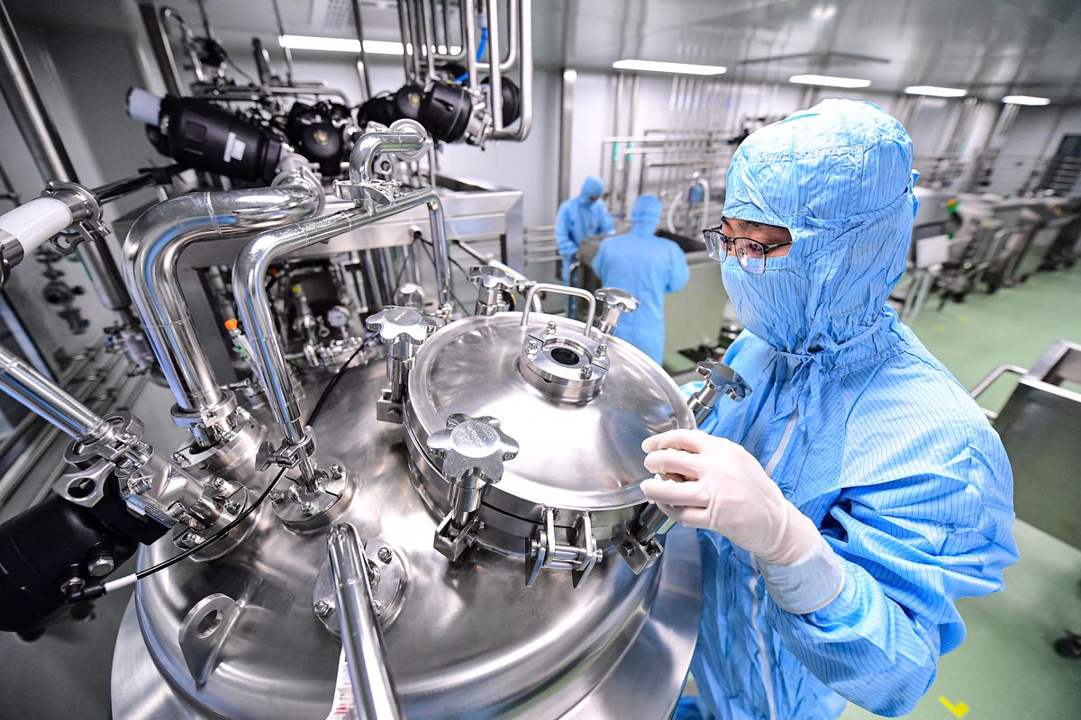 An employee works at a facility producing a Covid-19 coronavirus vaccine, which is currently undergoing clinical tests, in Shenyang in China's northeastern Liaoning province on April 19, 2022. (Photo by AFP) / China OUT