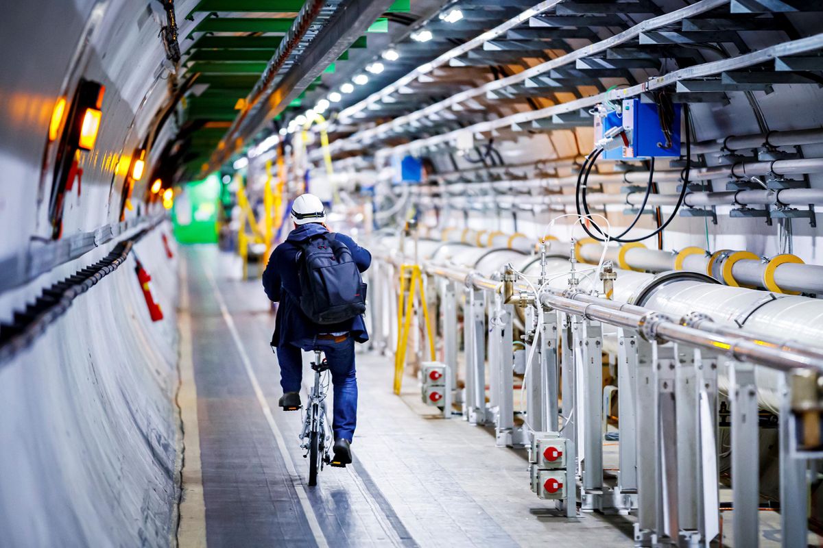 A man rides his bicycle along the beam line of the Large Hadron Collider (LHC) in a tunnel of the European Organisation for Nuclear Research (CERN), during maintenance works on February 6, 2020 in Echenevex, France, near Geneva. - Six years after the historic discovery of the Higgs boson, the world's largest particle accelerator is taking a break to boost its power, hoping to find new particles that would explain, among other things, dark matter, one of the great enigmas of the Universe. 