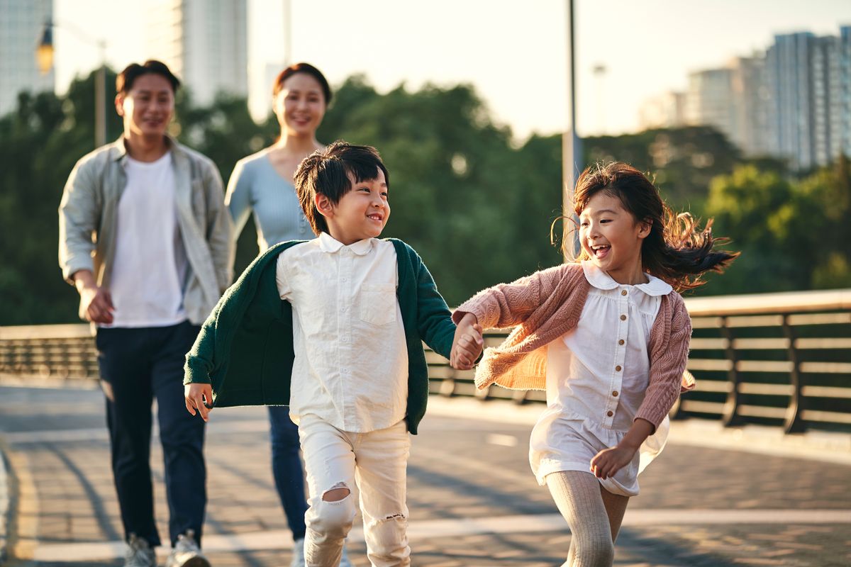 Happy,Asian,Family,With,Two,Children,Walking,On,Pedestrian,Bridge