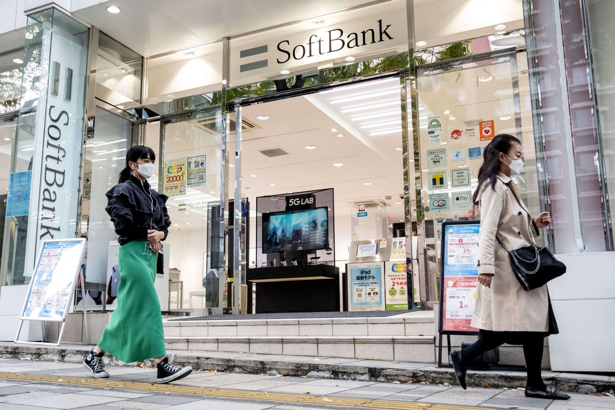 This picture taken on November 9, 2022 shows people walking past a mobile shop for Japan's SoftBank in Tokyo. - Softbank Group are expected to announce their second quarter results on November 11. (Photo by Yuichi YAMAZAKI / AFP)