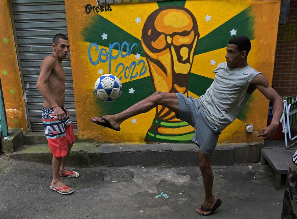 Residents play football in a street in Rocinha favela, Rio de Janeiro, Brazil, on November 22, 2022. (Photo by CARL DE SOUZA / AFP)