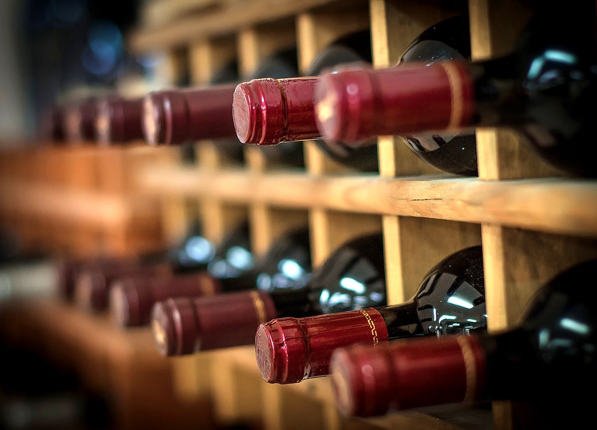 Red,Wine,Bottles,Stacked,On,Wooden,Racks, Red wine bottles stacked on wooden racks