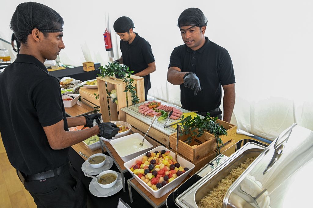 Employees prepare food in a dining hall at the Al-Emadi fan village in Doha on November 9, 2022, ahead of the Qatar 2022 FIFA World Cup football tournament. (Photo by Kirill KUDRYAVTSEV / AFP)