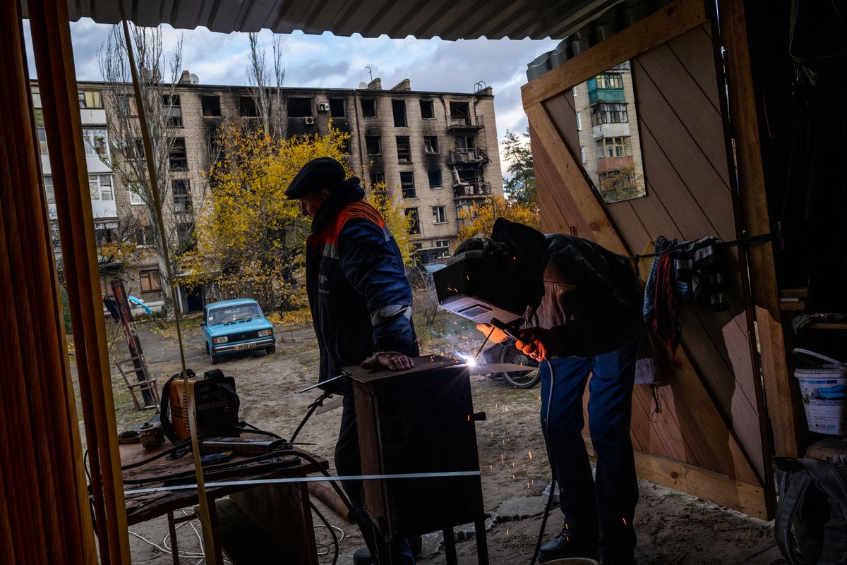 IZYUM, UKRAINE - OCTOBER 31: Vitali cuts a sheet of steel and welds together a stove heater, one of many, for his neighbors as gas heating still isn’t available in his neighborhood in Lyman, Ukraine on Oct 31, 2022 Wolfgang Schwan / Anadolu Agency 