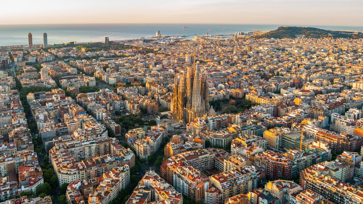 Sagrada Familia and Barcelona skyline at sunrise, aerial view. Catalonia, Spain, Barcelona's Grid pattern truly comes to life when viewed from above.