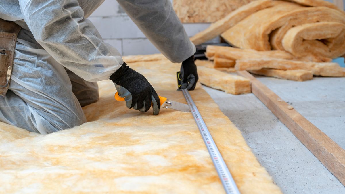 Cropped,View,Of,Professional,Workman,In,Protective,Workwear,Using,Knife, Cropped view of professional workman in protective workwear using knife and holding measuring tape over material, installing thermal insulation rock wool under the roof
otthonfelújítás, energetika