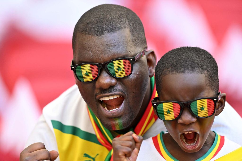 Senegal supporters pose for a picture ahead of the Qatar 2022 World Cup Group A football match between Qatar and Senegal at the Al-Thumama Stadium in Doha on November 25, 2022. (Photo by Glyn KIRK / AFP)