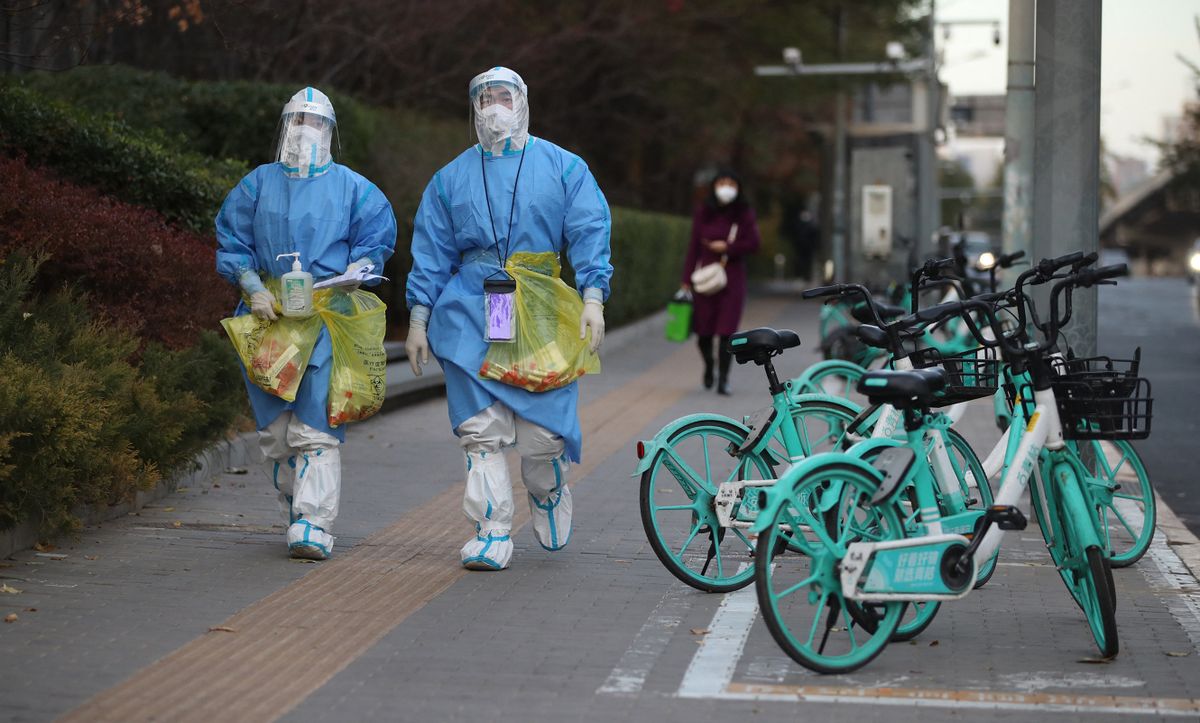 Medical staffs wearing protective gears carry specimens n Chaoyang district, Beijing on Nov. 21, 2022. Dining inside restaurants are prohibited due to provide COVID-19 infections.