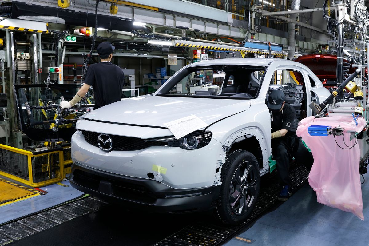 Workers assemble a Mazda Motor Corp. MX-30 EV Model vehicle on the production line at the company's Ujina plant in Fuchu Town, Hiroshima Prefecture, Japan, on Wednesday, June 15, 2022. To ease the impact of inflation, Prime Minister Fumio Kishida put together a series of relief measures including bigger gasoline subsidies. 