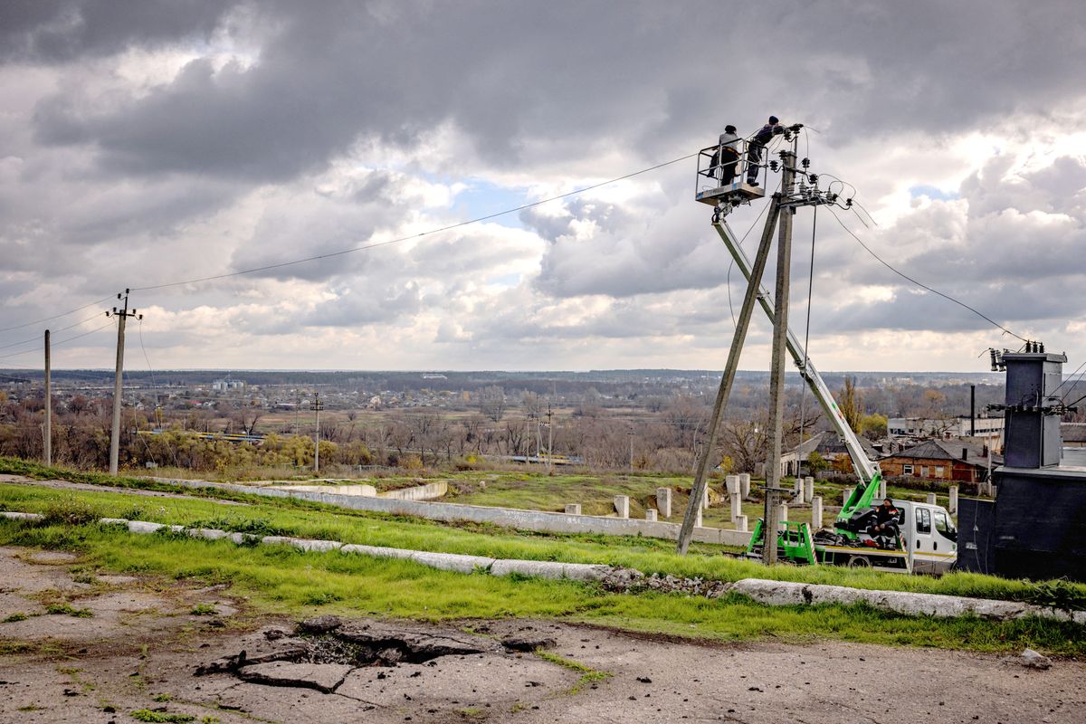 Communal workers repair power lines cut by shelling in the town of Kupiansk, Kharkiv region on November 3, 2022, which was formerly occupied by Russian forces. (Photo by Dimitar DILKOFF / AFP) ukrajna, áram, energia, 
