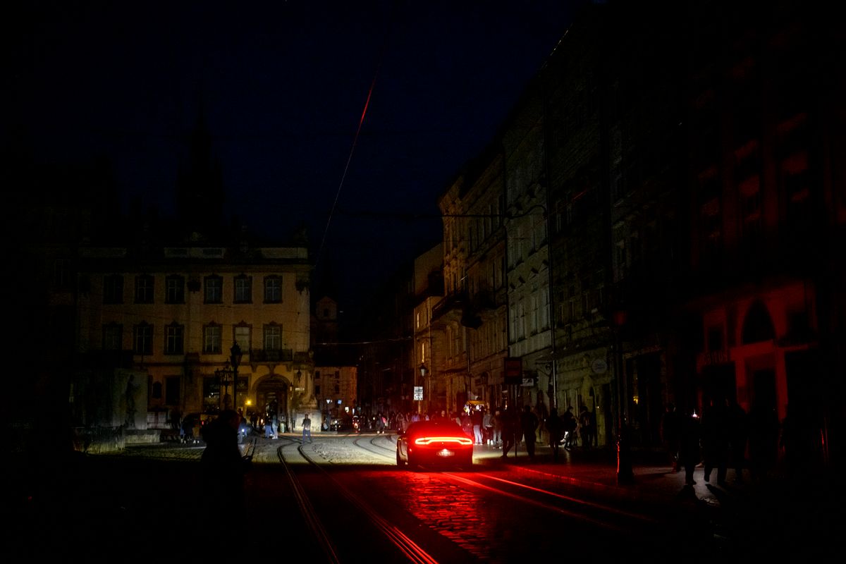 A Massive Russian Missile Attack On Ukrainian Power Infrastructure, People go by the dark street during a blackout after a massive Russian missile attack on Ukrainian power infrastructure in Lviv, Ukraine, November 15, 2022 (Photo by Maxym Marusenko/NurPhoto) (Photo by Maxym Marusenko / NurPhoto / NurPhoto via AFP)