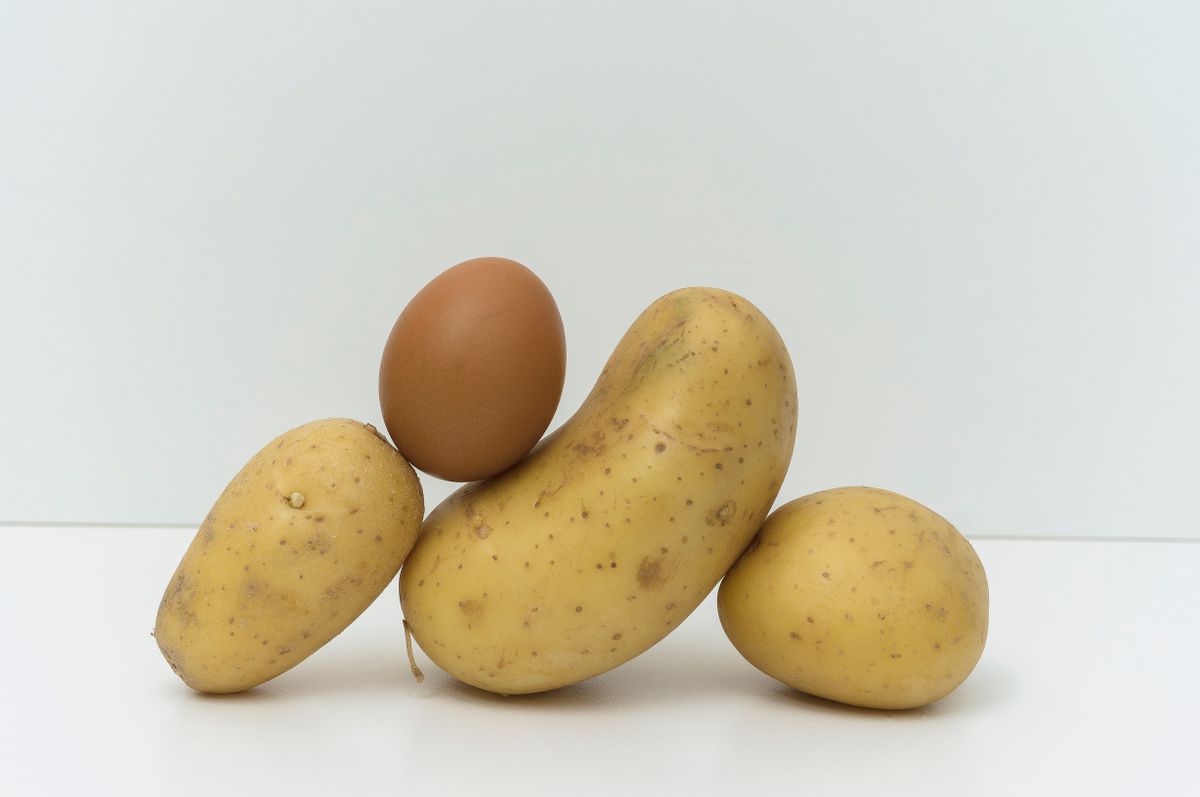 Balanced,Composition,With,Raw,Potatoes,And,Egg,On,A,White