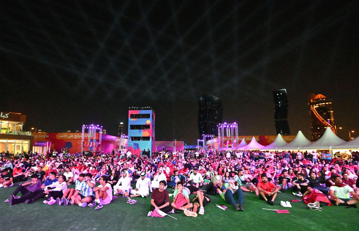 People watch a live broadcast of the 2022 World Cup opening match between Qatar and Ecuador at Hayya Fan Zone in Lusail, north of Doha, on November 20, 2022, during the Qatar 2022 World Cup football tournament. (Photo by Jung Yeon-je / AFP)